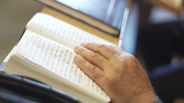 Old Man hand on tehillim book. Read tehillim in king david grave. Jerusalem, israel.
