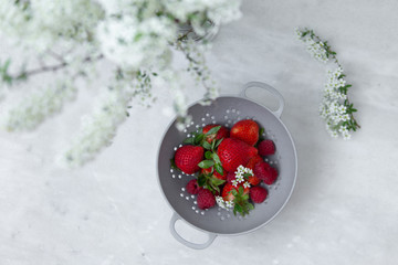 Summer healthy fruit composition with red strawberries and raspberries on marble background with copy space