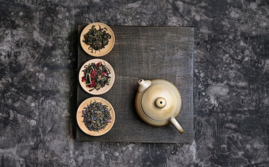 tea ceremony concept, Chinese or japanese traditions. teapot, several kinds of tea welding on dark background. variety of tea selection. Asia culture design concept. Top view, copy space