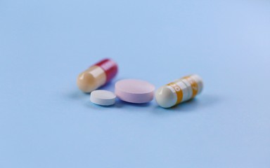 Pile of pills on blue texture background