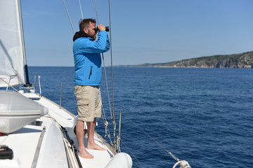Man sailing with sails out on a sunny day