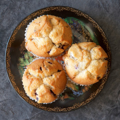 Three blueberry muffins on a plate.
