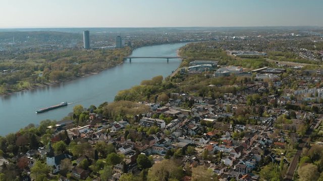 Drone / Aerial panorama shot of bonn with the konrad adenauer bridge, the river rhine with a ship, the Kameha Grand hotel and the post tower 30p