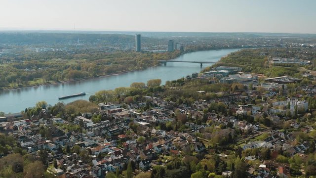 Drone / Aerial panorama shot bonn with the konrad adenauer bridge, the river rhine with a ship, the Kameha Grand hotel and the post tower 30p