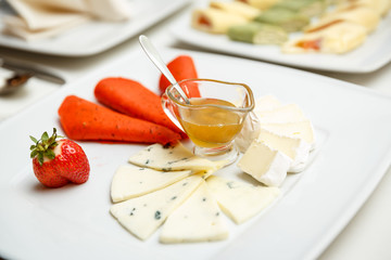 Cheese plate with honey served in a restaurant