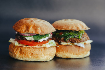 Burger flyer. Cheese burger with grilled meat, cheese, salad and onion rings. Close-up of delicious fresh home made burger with salad and cheese on bark blue background