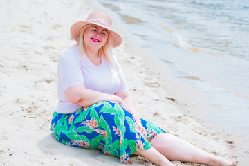 Plus size model at summertime. Overweight woman in beach enjoying the life . Beautiful xxl young lady on a sand rest at nature near river, concept of woman's life 