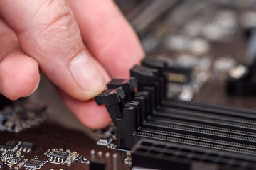 Male hand taking out ram memory on motherboard