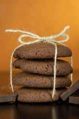 Tasty looking chocolate cookie on dark surface. Vintage warm background