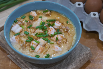 Steamed egg custard cuisine in a blue bowl with minced pork, sausage and shrimp. Or Only with egg, water, salt and some sesame oil, you can make this super smooth custard.