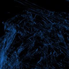  Transparent blue plastic wrap on the black background. Plastic shopping bag texture. Reusable trash and waste.