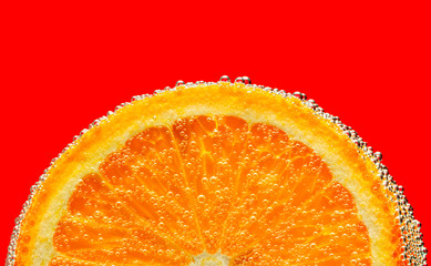 Cheerful orange in air bubbles. Macro red background