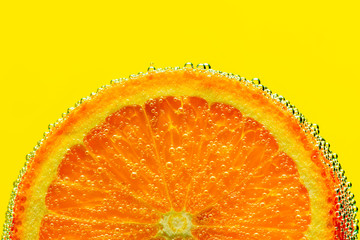 Cheerful orange in air bubbles. Macro yellow background