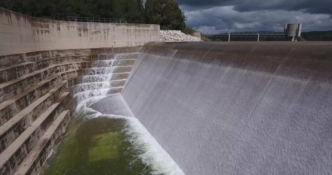 Cinematic POV Aerial of Concrete Cascade Channels at Artificial Dam With View of Controlled Lake Water Surface and Forest Surroundings 4k