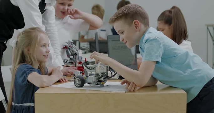 Curious kids working on a functional programable robot during robotics class at school. 4K UHD 60 FPS SLOW MOTION