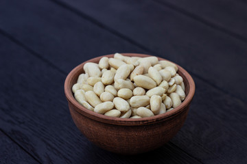 peanuts in ceramic bowl on oak table