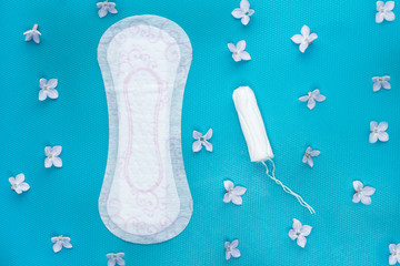 Woman hygiene protection during periods. Menstruation pads, tampon and flowers.