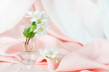 Spring still life with white flowers on a background of pink silk