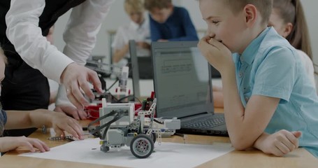 Curious kids working on a functional programable robot during robotics class at school. 4K UHD 60 FPS SLOW MOTION