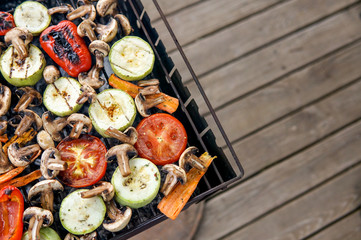 Healthy food preparing outdoors on summer or spring picnic. Grilled vegetables on grill on coals. Barbecue picnic on a meadow