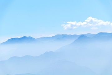 Obraz premium Abstract cascade mountain chains silhouette landscape nackground in a light blue mist sky in morning Andes