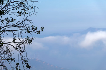 Abstract cascade mountain chains silhouette landscape nackground in a light blue mist sky in morning Andes