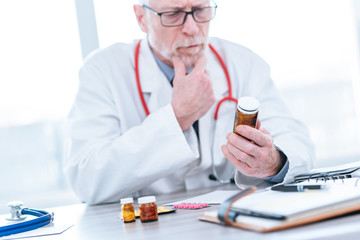 Doctor looking at a bottle of pills