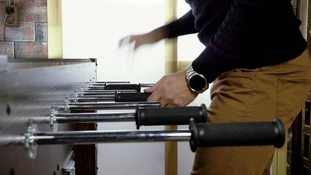 Sport, game concept. Foosball. One man playing a table football or kicker with miniature players. 4K
