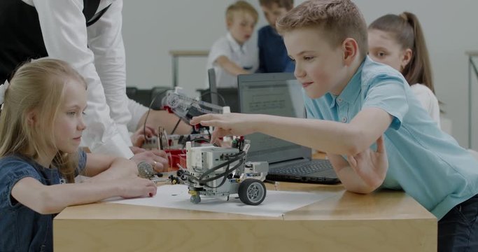 Curious kids working on a functional programable robot during robotics class at school. 4K UHD 60 FPS SLOW MOTION