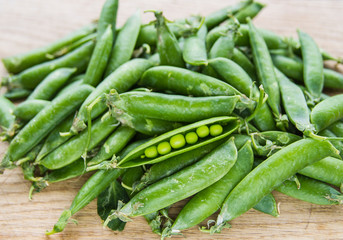 green pea pods on wooden background