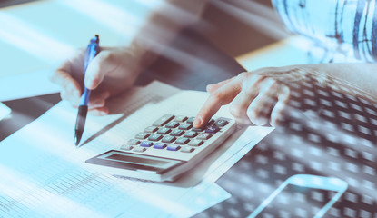 Female accountant using calculator;  light effect
