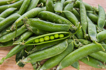 green pea pods on wooden background
