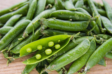 green pea pods on wooden background