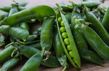 green pea pods on wooden background