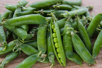 green pea pods on wooden background
