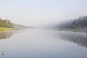 Photo of fog over the river in the early summer morning