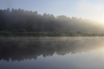 Photo of fog over the pond in the early summer morning