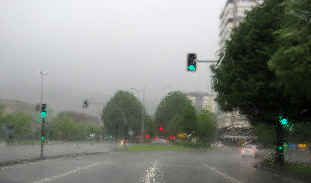 Lluvia sobre un parabrisas en una carretera de ciudad
