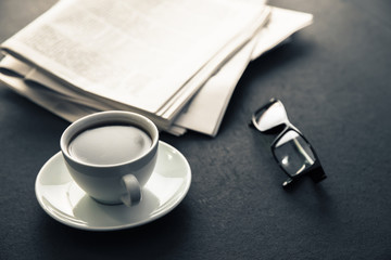 glasses on newspapers with coffee