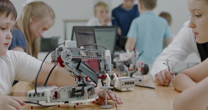 Curious kids working on a functional programable robot during robotics class at school. 4K UHD 60 FPS SLOW MOTION