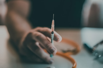 Addict at the table with a syringe heroin methamphetamine addiction