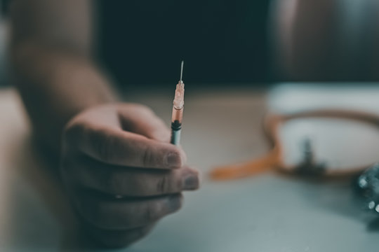 Addict at the table with a syringe heroin methamphetamine addiction