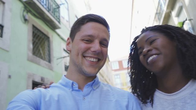 Happy young couple looking at camera. Handsome Caucasian man with piercing and beautiful African American woman with dreadlocks posing for selfie. Concept of self portrait