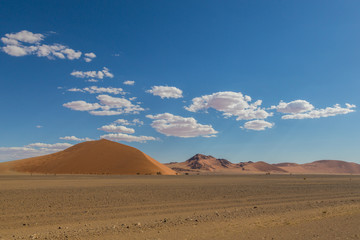 Namib desert with sand dunes, clouds, blue sky