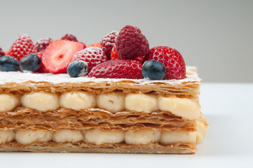 Puff pastry cake with custard cream. Close-up of sweet summer dessert with berries. Food concept