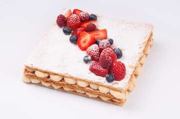 Close-up of delicious berry cake with powder sugar on top layer. Natural cake with custard cream. Dessert concept 