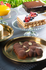 Collection of various cakes on table. Close-up of fresh masterpiece desserts of candy bar outdoors. Party concept