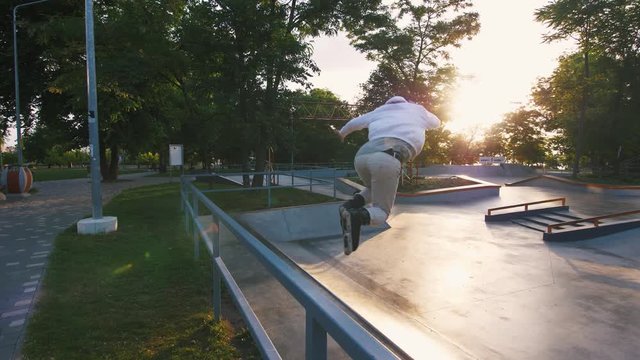 Aggressive Inline roller skater doing tricks in concrete skatepark outdoors, slow motion, tracking shot
