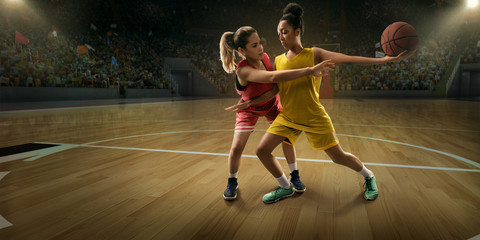 Female basketball players fight for the ball. Basketball players on big professional arena during the game © Alex