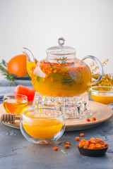 A bright orange teapot on a white background and a stone table
